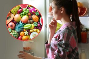 Donna che guarda frigorifero, frutta