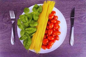 piatto con basilico, spaghetti e pomodorini