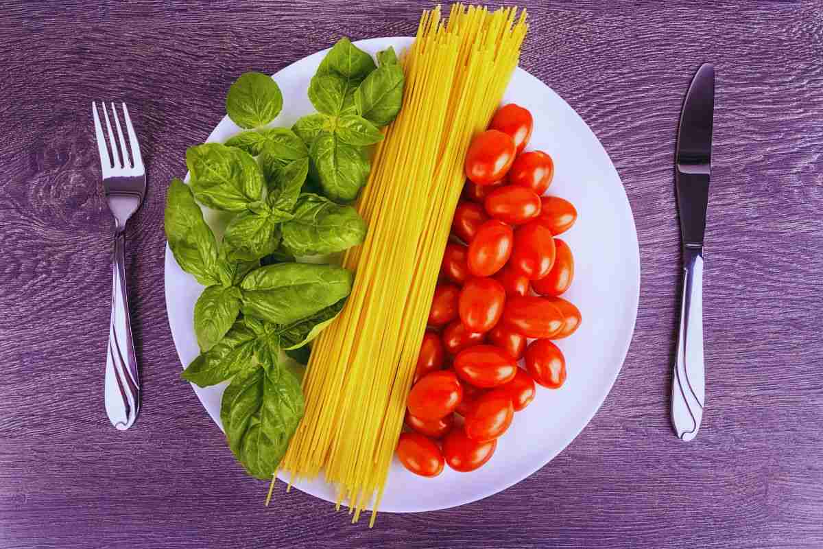 piatto con basilico, spaghetti e pomodorini