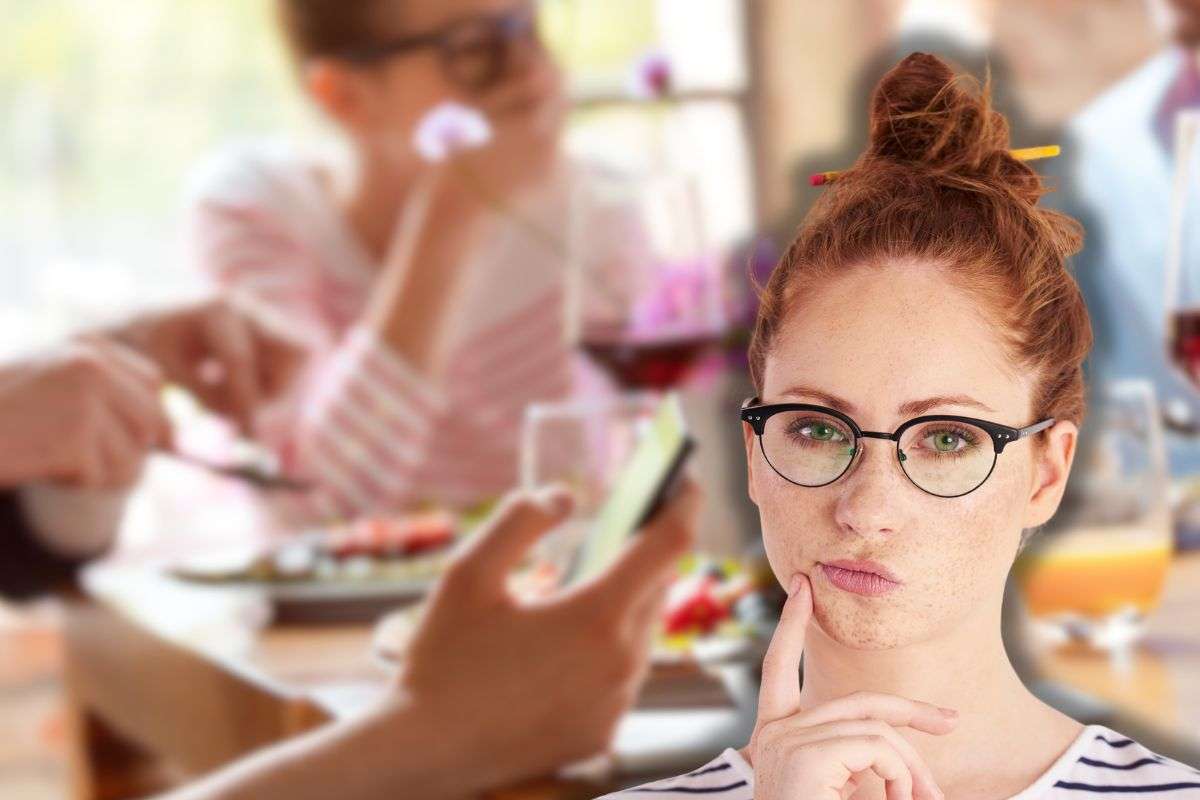 persone a pranzo con telefono in mano a tavola e una dona che pensa